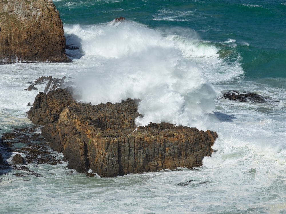 brown rock formation on sea during daytime