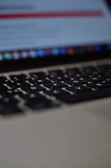 Close-up of a laptop keyboard with screen blurred