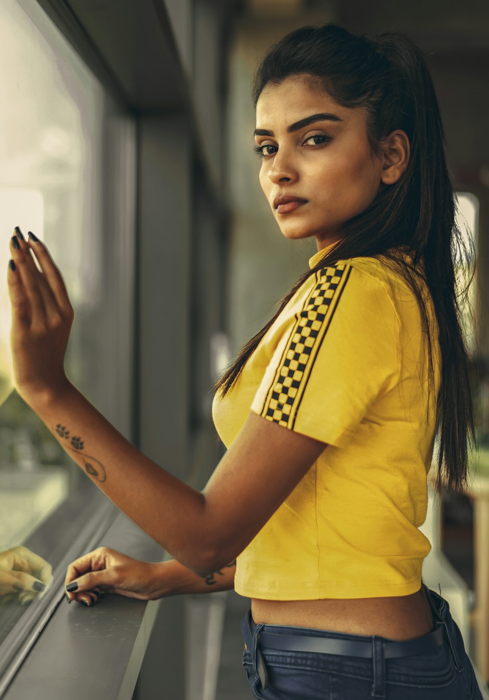 femme en chemise jaune et noire debout et souriante