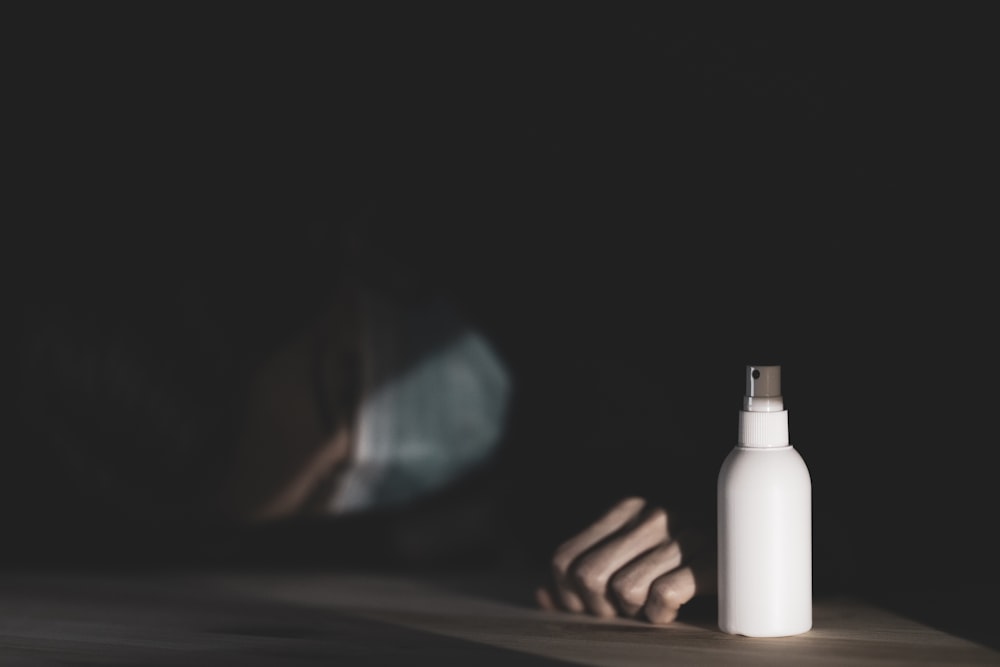 person holding white plastic bottle