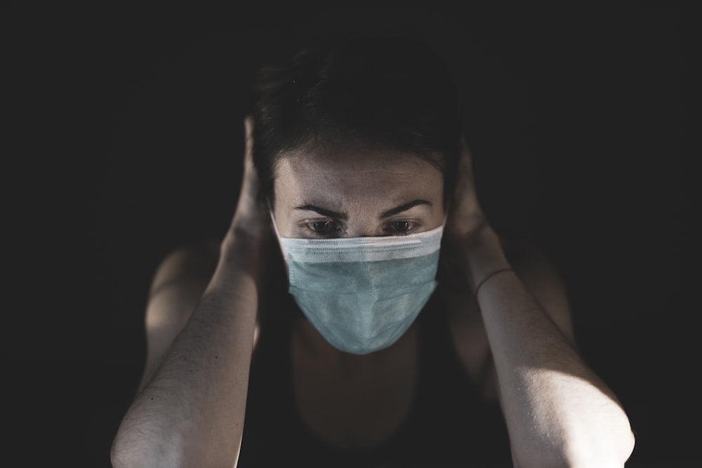 Mujer cubriendo su cara con pintura verde azulado