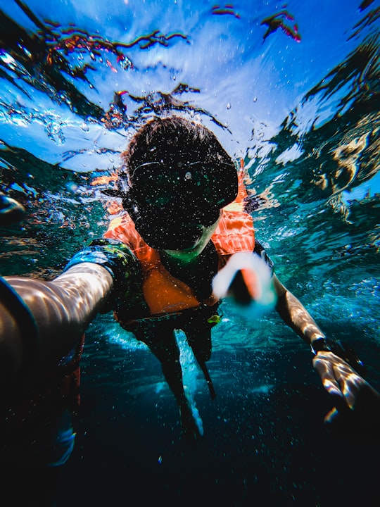 boy in blue and white shorts swimming in water in Satun Thailand