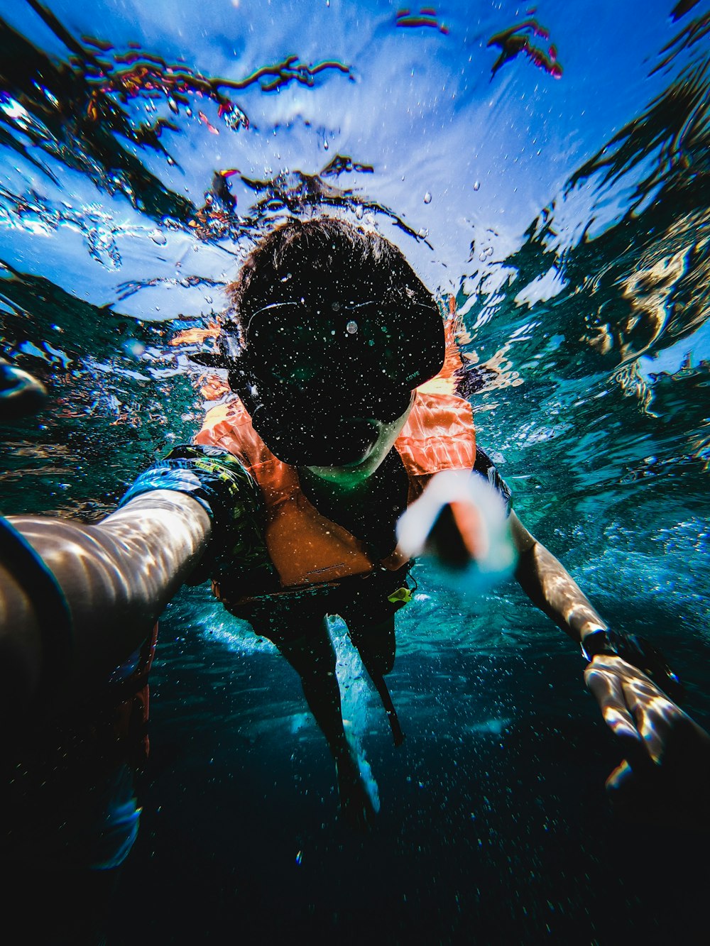 boy in blue and white shorts swimming in water