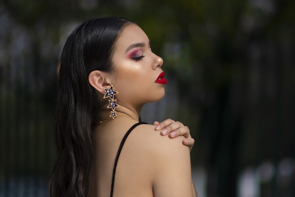 woman in black spaghetti strap top wearing silver earrings