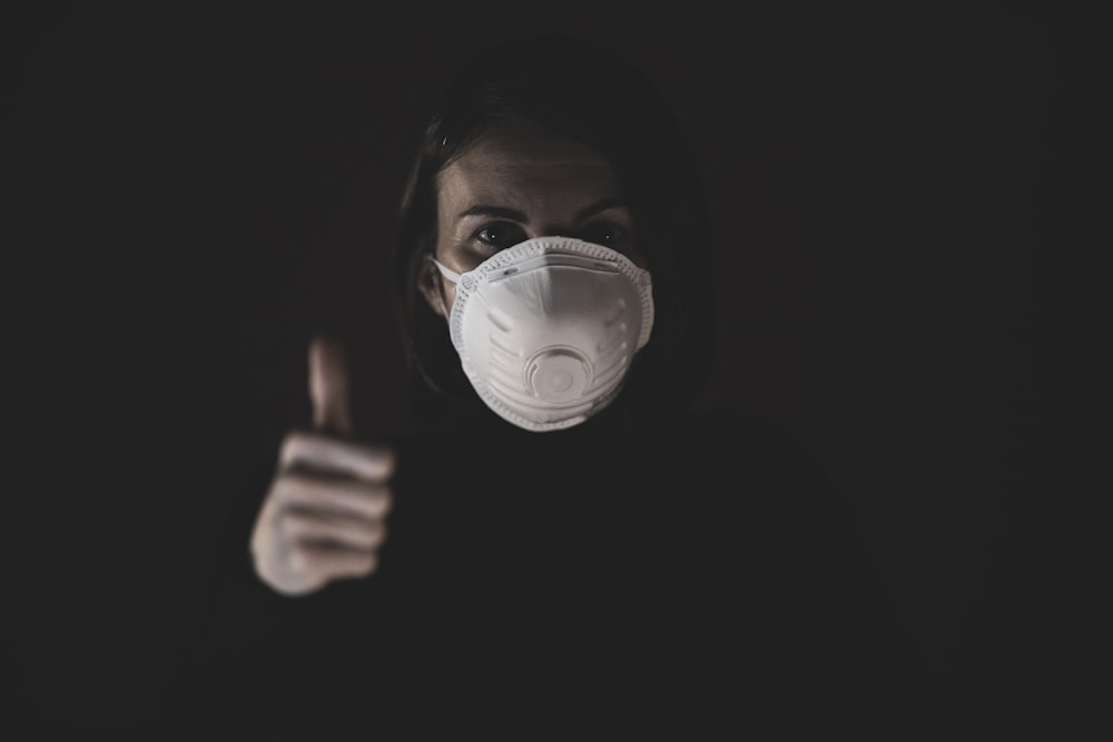 woman holding light bulb in dark room