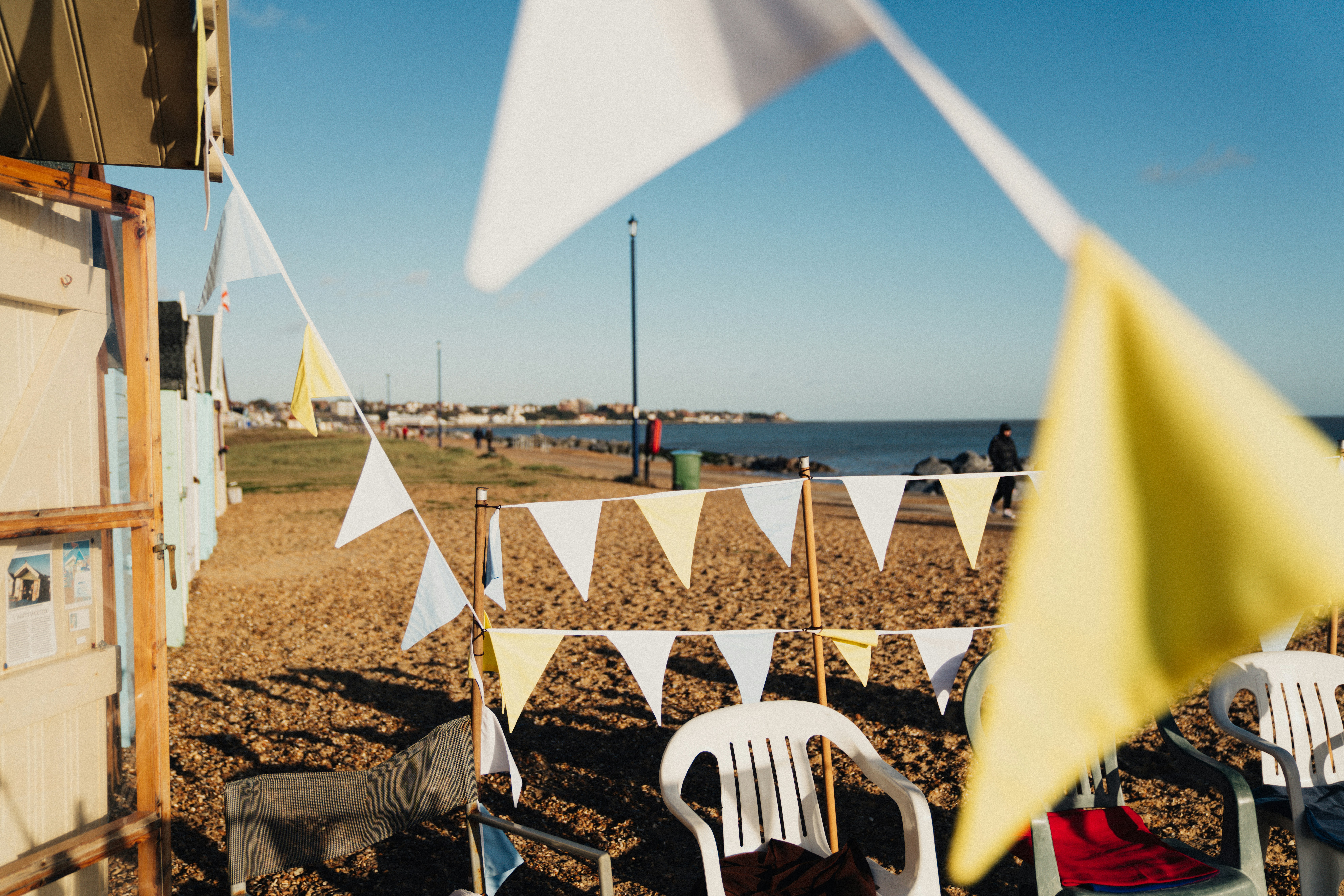 white plastic chairs on beach during daytime