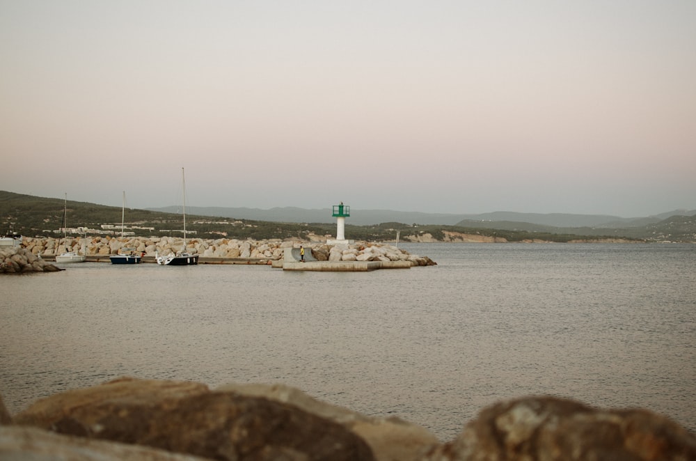 white lighthouse near body of water during daytime