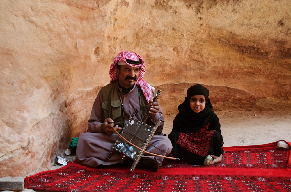 a man and a woman sitting on a rug