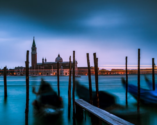 body of water near city buildings during night time in Church of San Giorgio Maggiore Italy