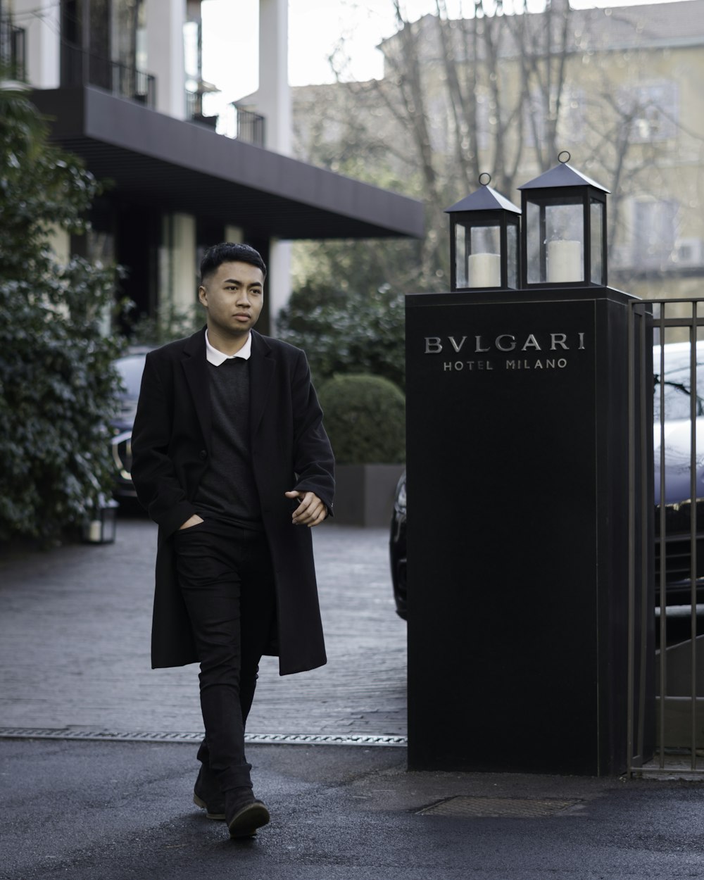 a man walking down a street next to a tall building