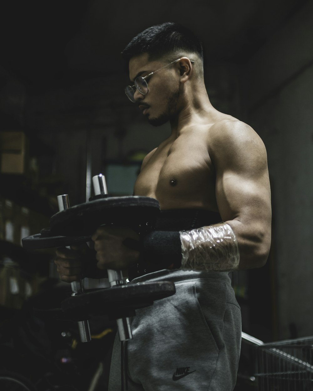 topless man in gray pants wearing black sunglasses