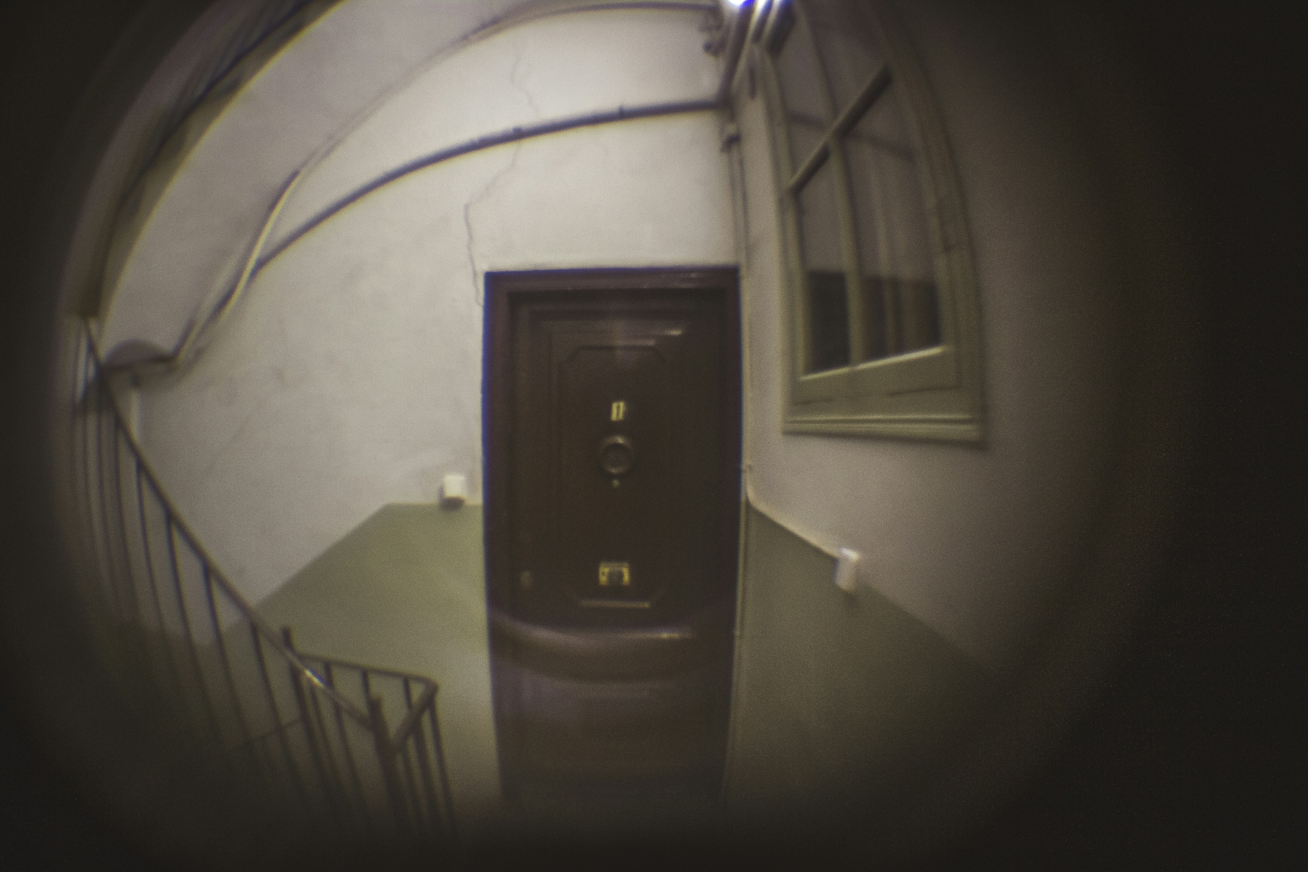 A view of a door through a fish eye lens peephole