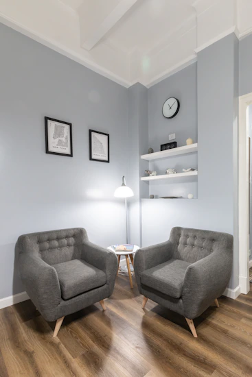 gray sofa chair beside white floor lamp