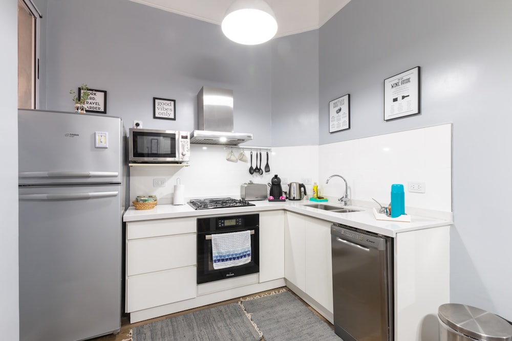 white top mount refrigerator beside white microwave oven