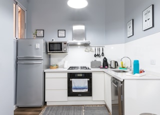 white top mount refrigerator beside white wall