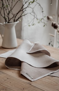white ceramic vase on brown wooden table