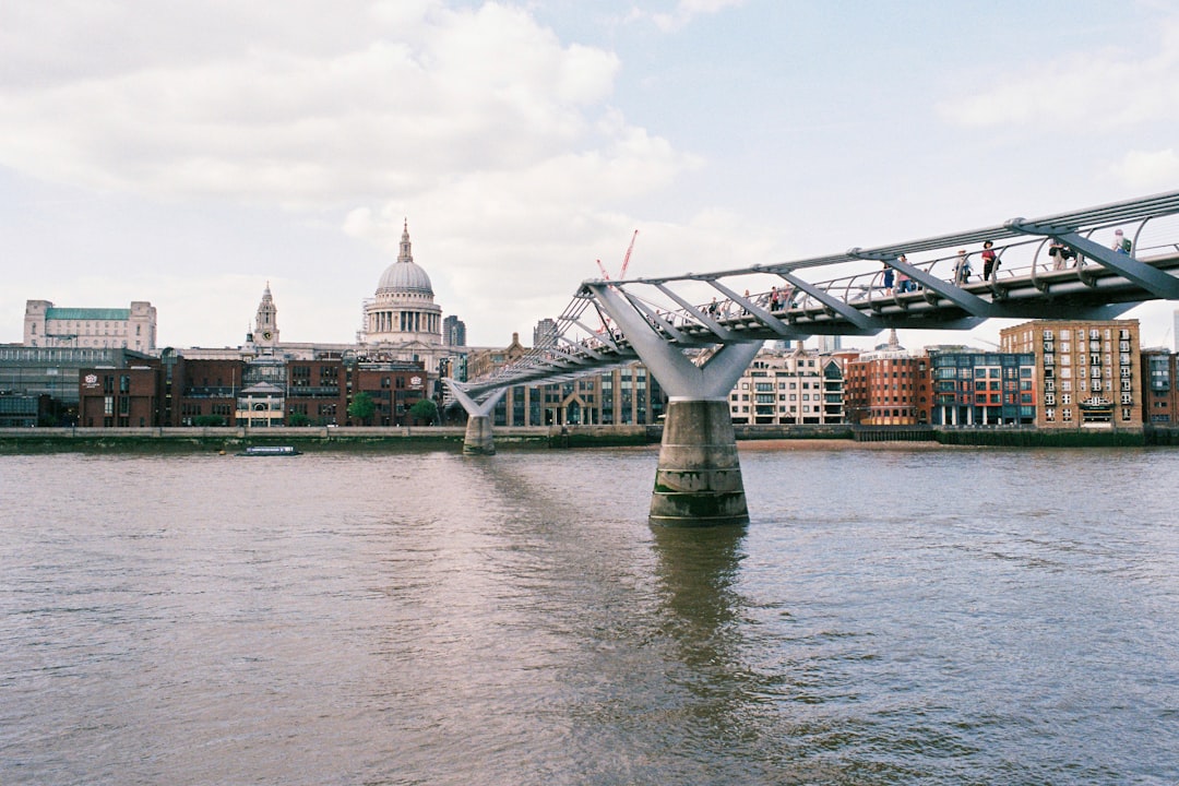 brown and white concrete building near bridge under white sky during daytime