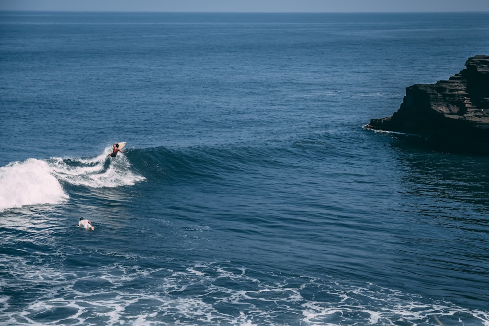 昼間、海でサーフィンをする男性