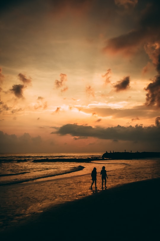 silhouette of 2 people walking on beach during sunset in Canggu Indonesia