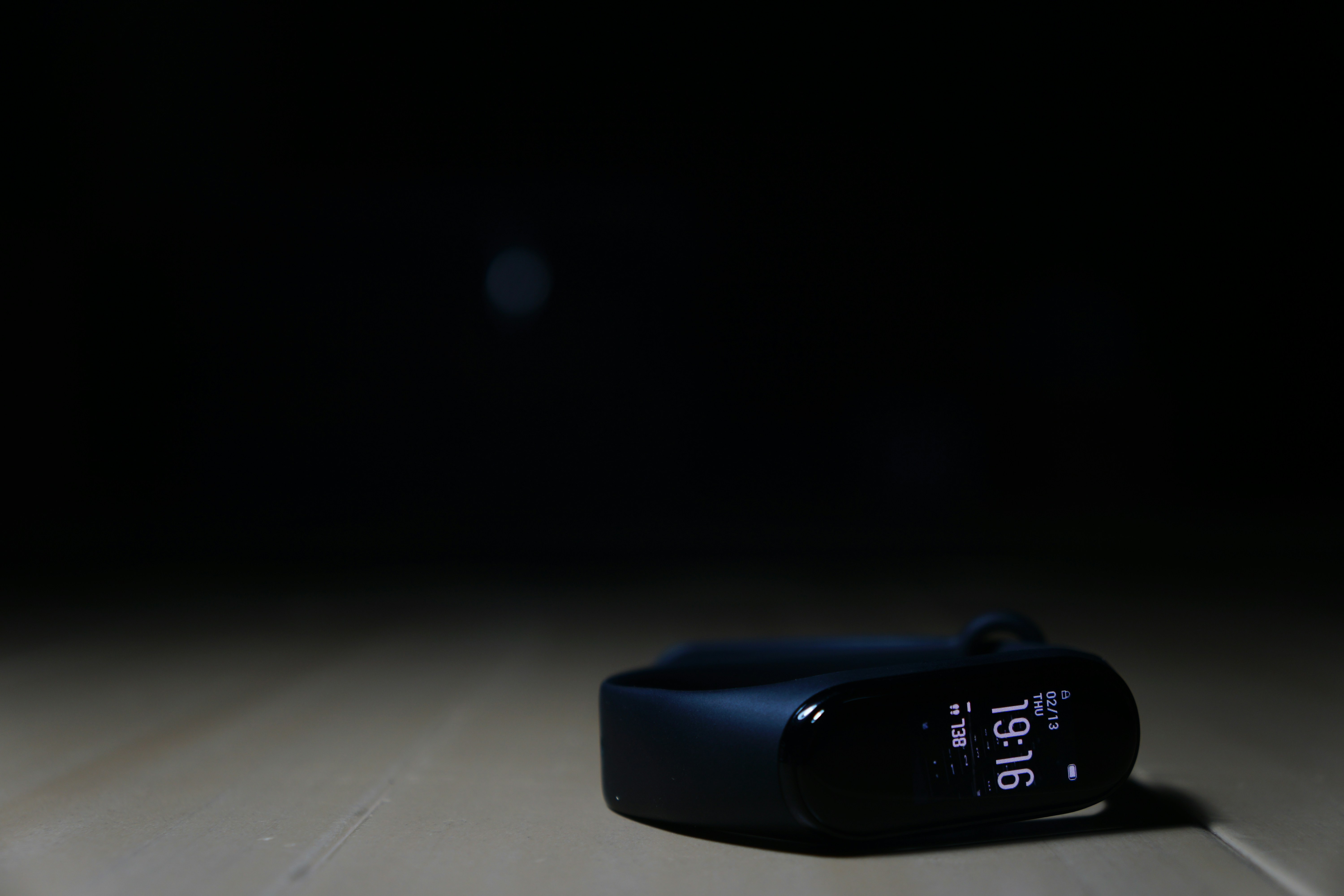 A small, discreet sleep tracking device on a bedside table.