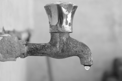 gray scale photo of faucet