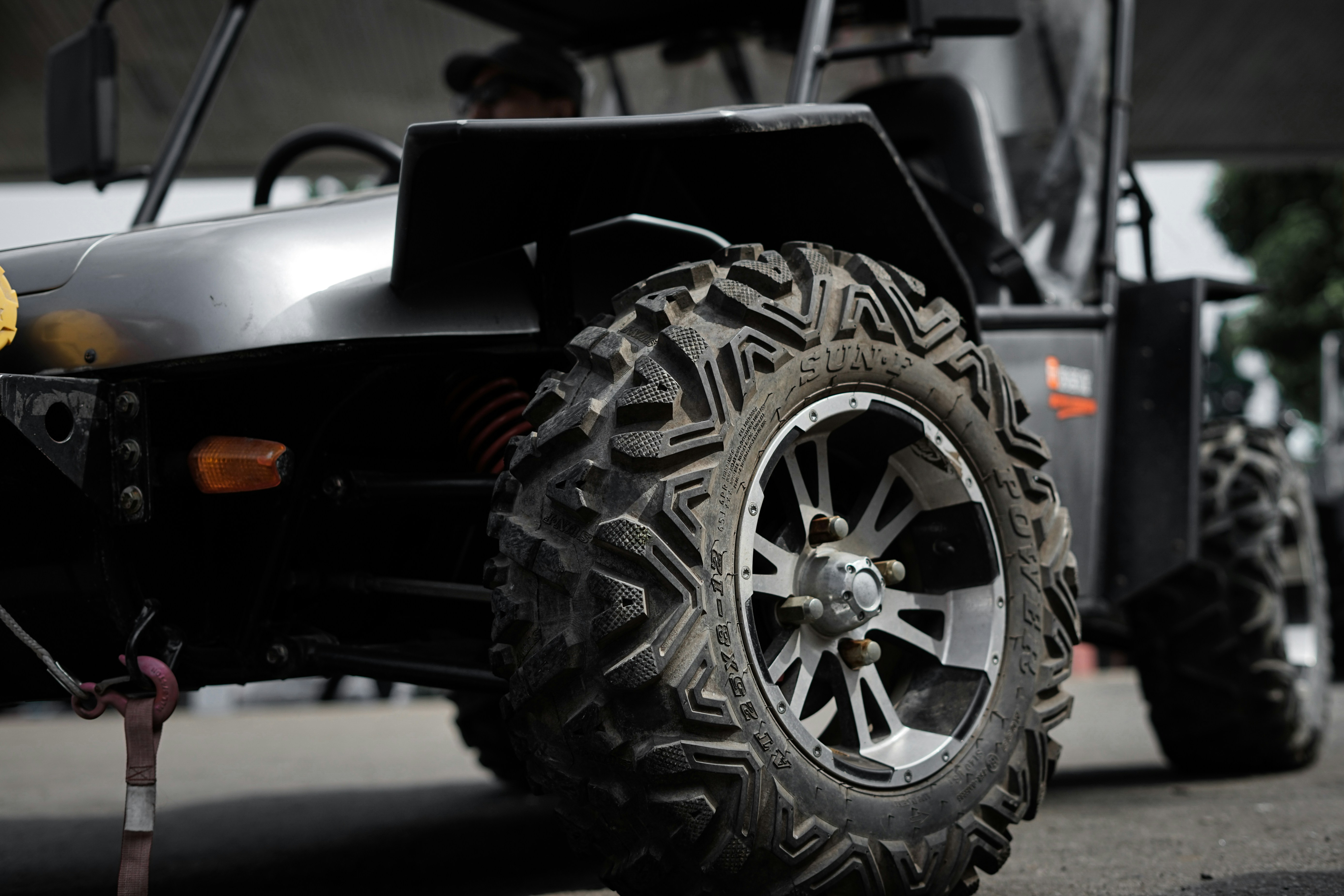 Close-up of a premium 10-inch machined aluminum golf cart rim with an aggressive all-terrain tire