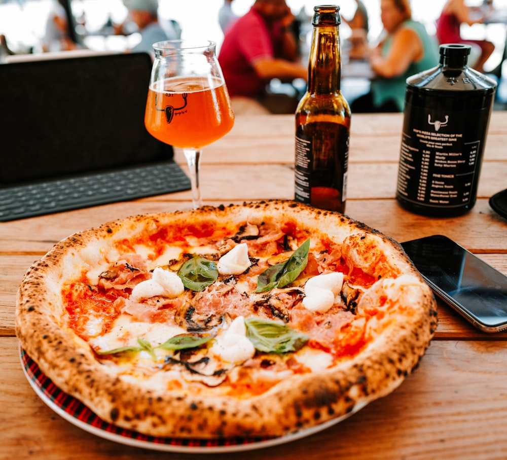 pizza with green leaf vegetable and sauce on brown wooden table