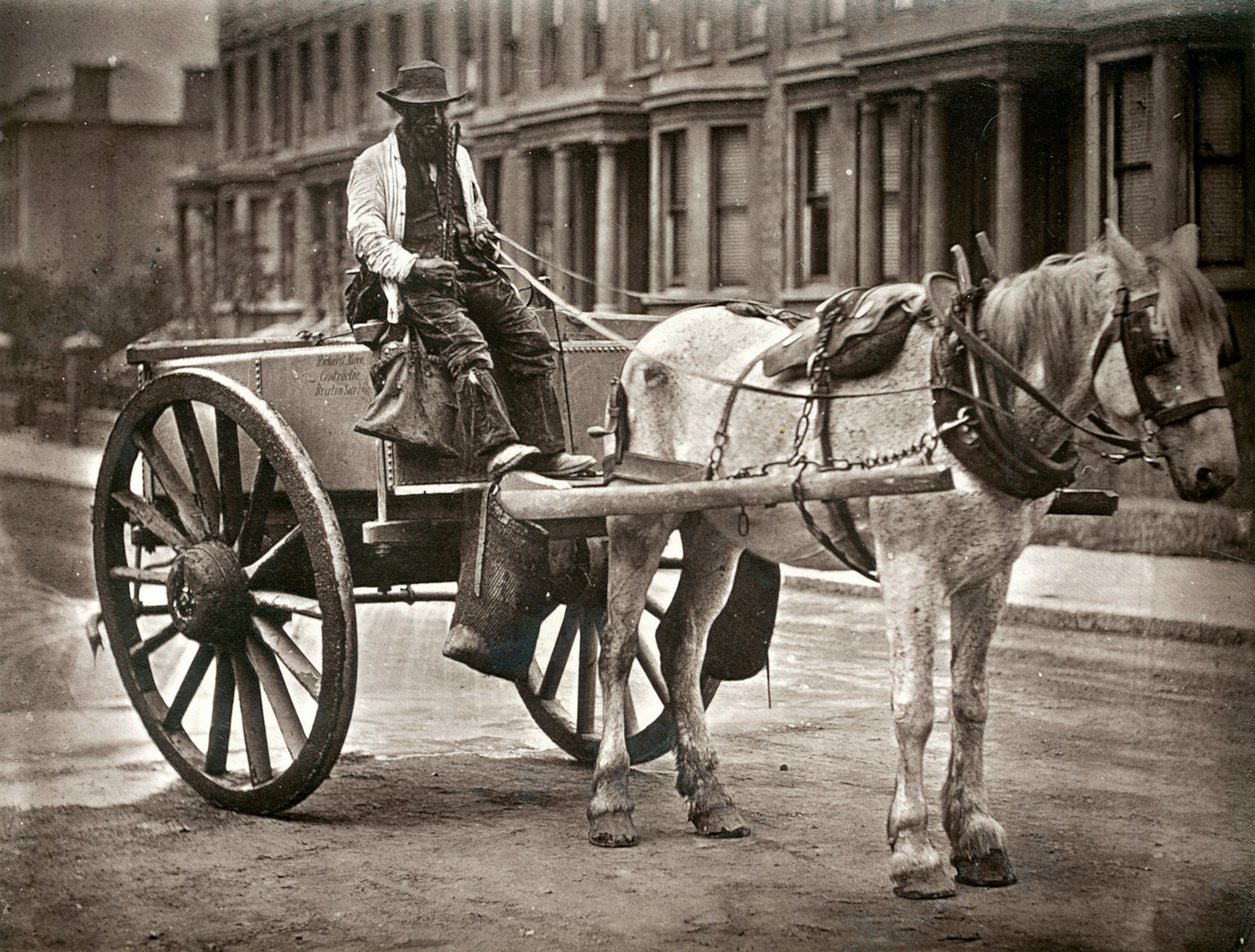 grayscale photo of a man in a cart pulled by a horse