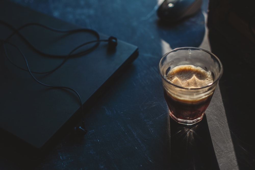 clear drinking glass with brown liquid