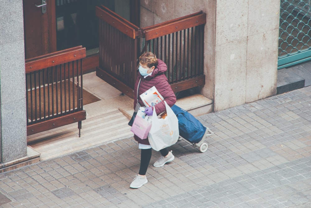 woman in pink long sleeve shirt carrying baby in white stroller