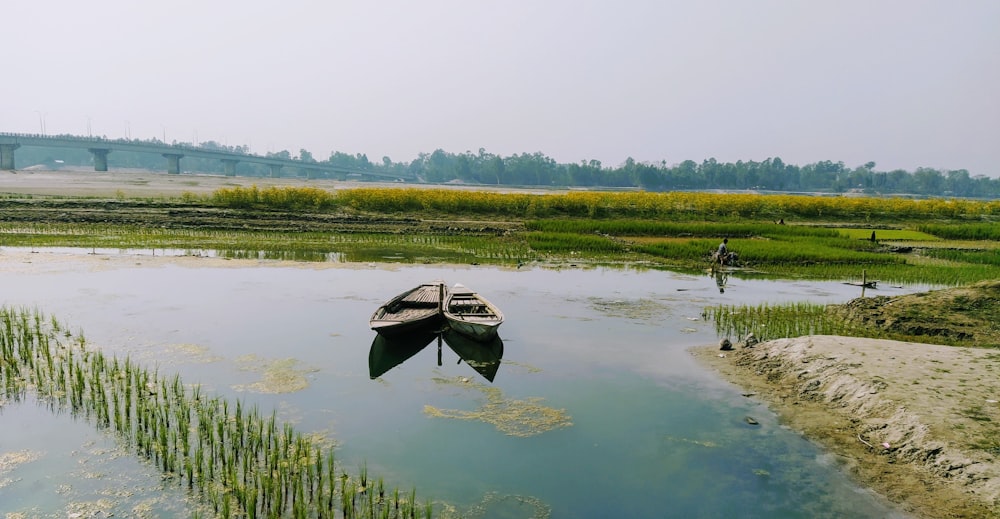 a couple of boats floating on top of a lake