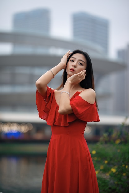 Woman wearing elegant red dress in urban setting