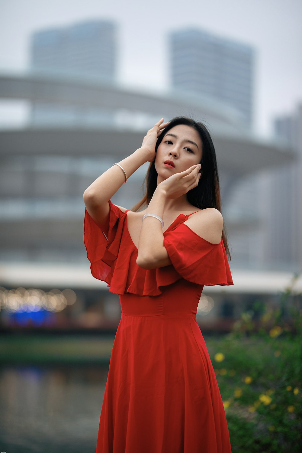 woman in orange dress standing on green grass field during daytime