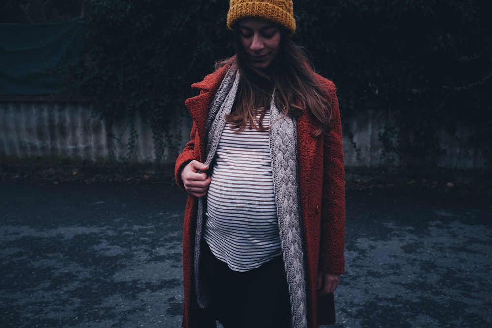 woman in red coat and black and white striped shirt