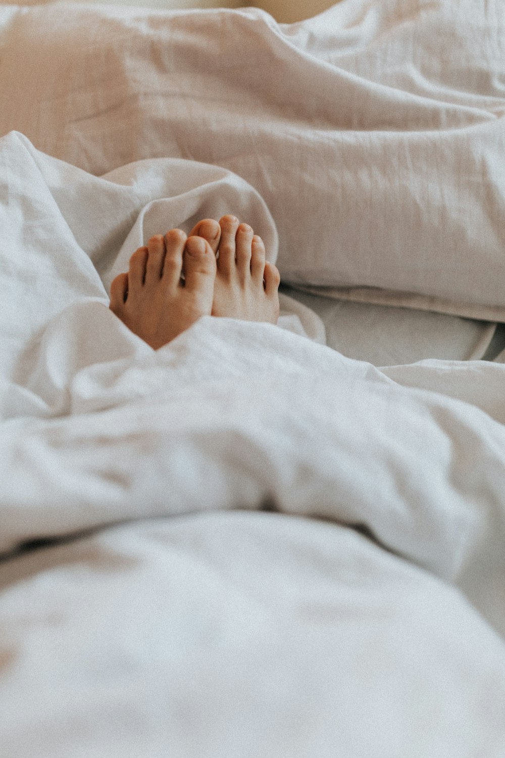 person lying on white bed