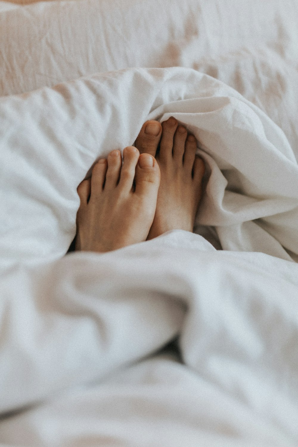 persons feet on white textile