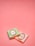 Two small wrapped chocolates lie on a pink surface. The wrapping includes elegant branding with the text 'Laduree Paris' and decorative golden embellishments. One wrapper is pastel green, and the other is a light pink.