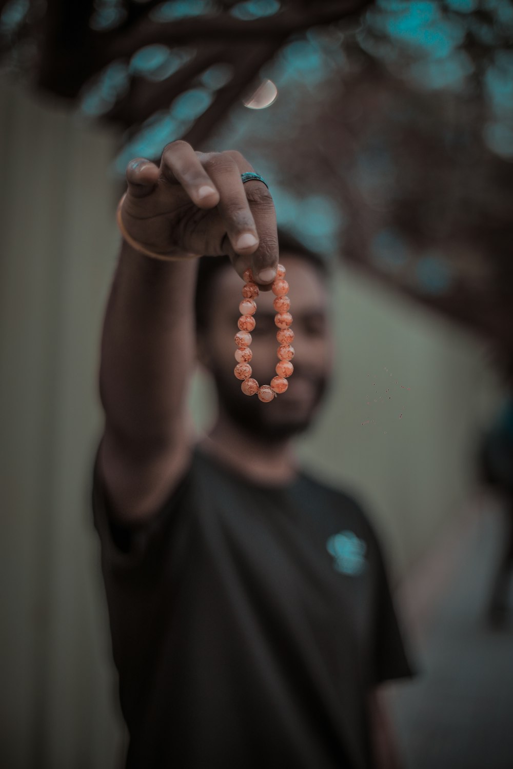 persona sosteniendo pulsera de cuentas naranjas