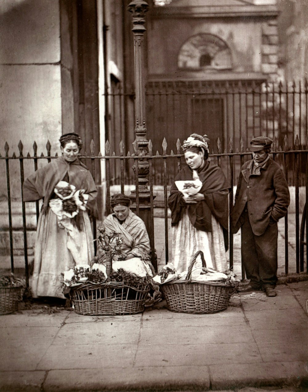 a group of people standing next to each other on a sidewalk