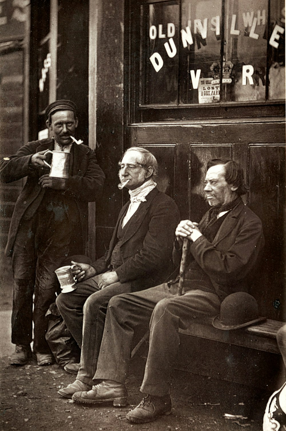 man in black suit jacket sitting beside man in black suit