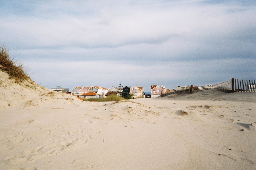 white and brown houses on brown sand under white clouds during daytime