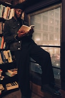 A person reading a book in a cozy, well-lit space.