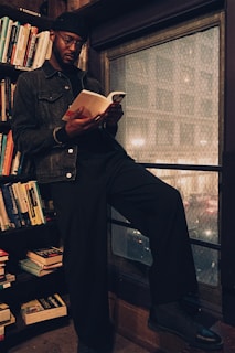 A person reading a book in a cozy, well-lit space.