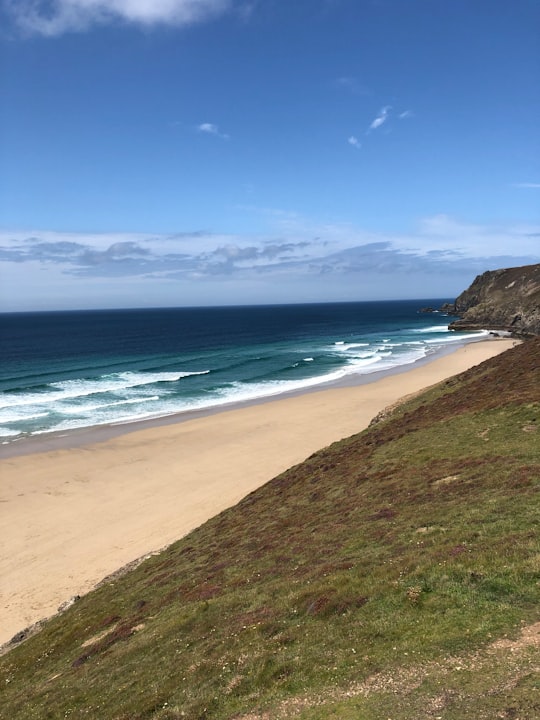 green grass field near body of water during daytime in St Agnes United Kingdom