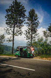 A friendly local driver helping tourists with luggage beside a cab near Tsomgo Lake.