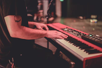 person playing piano in grayscale photography
