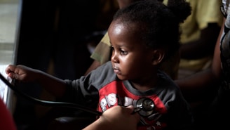 A caring pediatrician examining a young child in a bright clinic room.