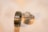 A pair of gold rings with intricate detailing. One is a wide band with a smooth finish, while the other is a more delicate ring featuring a square-shaped diamond surrounded by smaller diamonds, likely an engagement ring.