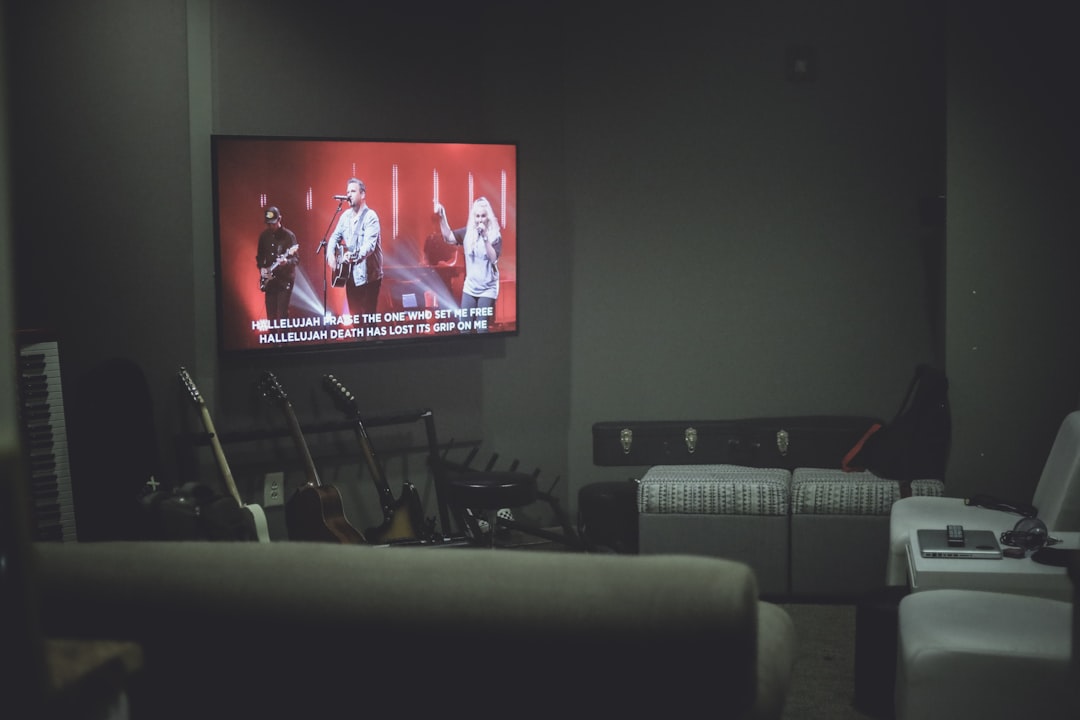 black flat screen tv turned on displaying man in red shirt