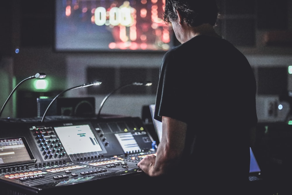 man in black t-shirt playing audio mixer